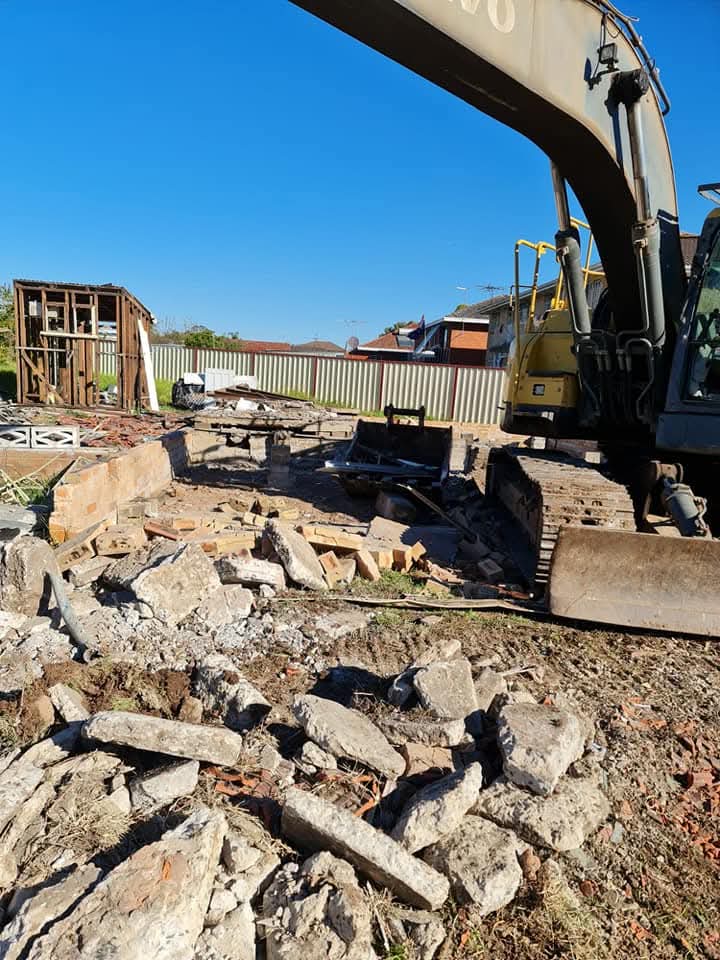 Excavator demolishing roof with bucket close-up
