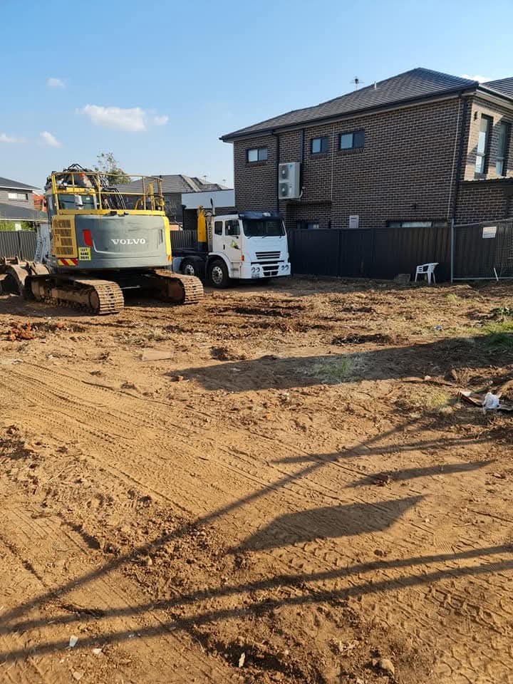 Volvo excavator and truck on cleared residential block