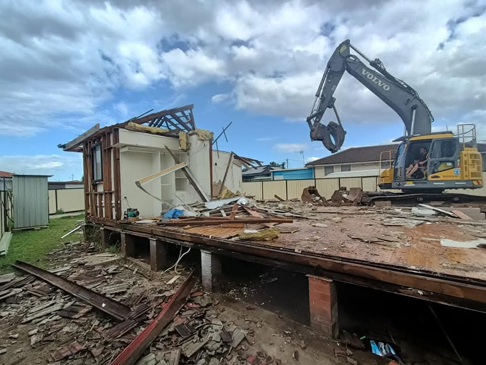 Volvo excavator demolishing weatherboard home